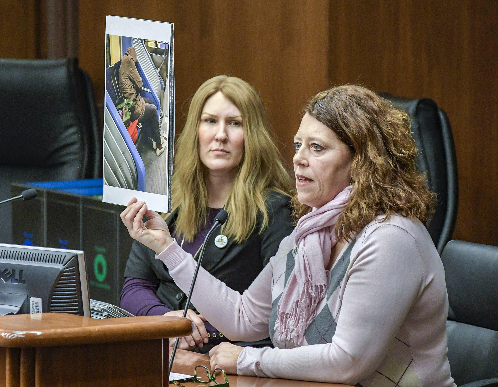 Allison Streich, left, co-chair of Homes for All, listens as Monica Nilsson shares stories of homelessness Jan. 23 with the House Housing Finance and Policy Division. Photo by Andrew VonBank